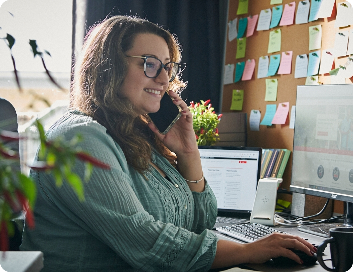 Woman working at her desk while talking on the phone